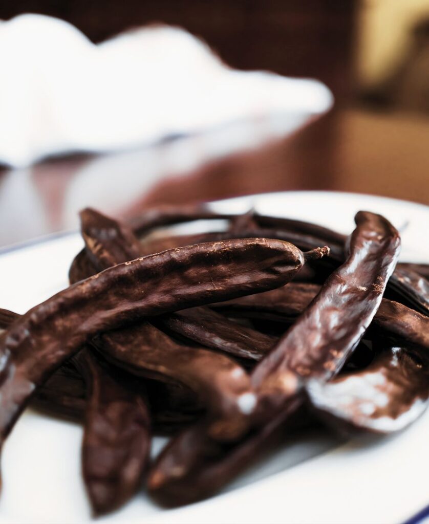 gousses de caroube sur une assiette comme snack naturel