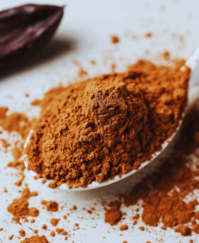 Carob powder compared to cocoa powder on a wihte surface