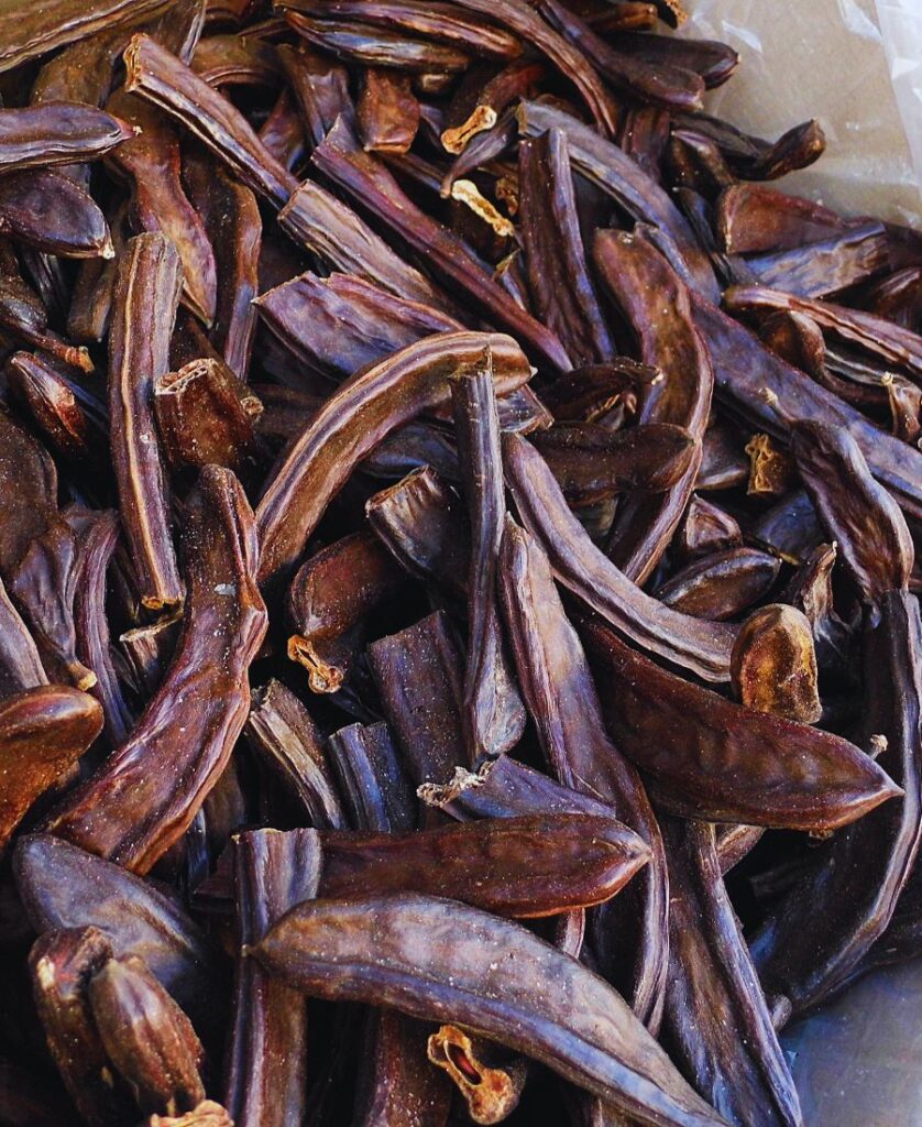 ripe carob pods in a bag
